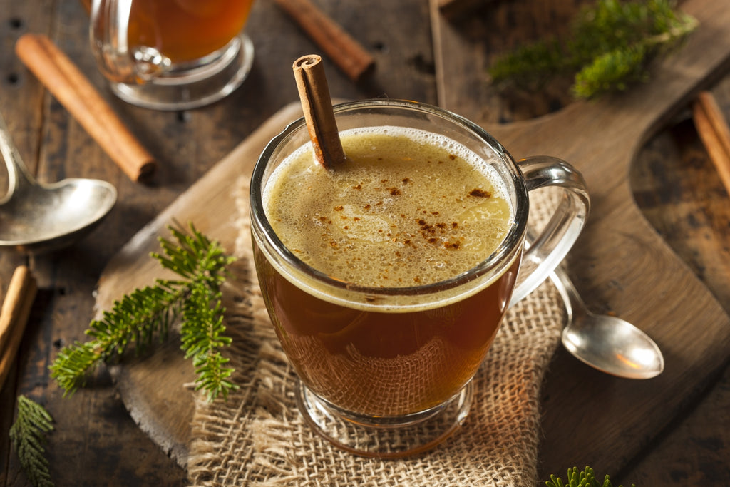 Clear glass Mug of Hot Butter Rum with cinnamon stick twizzler stick